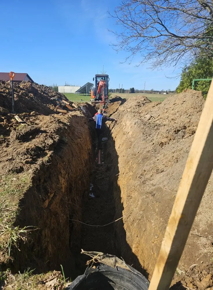 Iškasta tranšėja su ekskavatoriumi